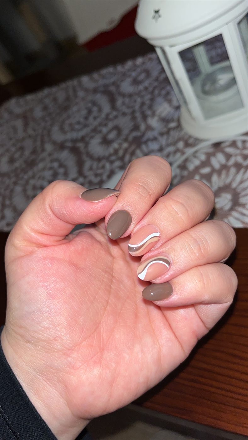 Uña corta natural con ondas blancas y beige sobre base transparente y tonos moka